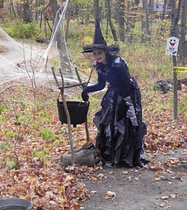 Spookamaga volunteer witch stirs potion in a cauldron