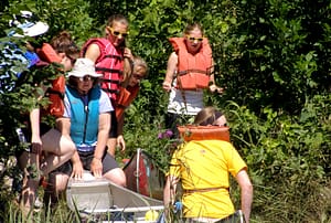 Girl scouts in life jackets as they canoe