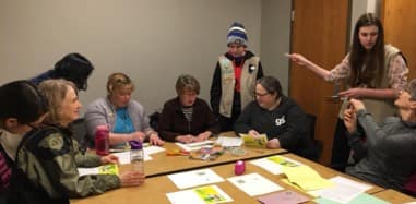 STEM group volunteers leading an activities with older Girl Scouts