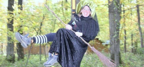 Spookamaga volunteer dressed as witch flies on a zipline
