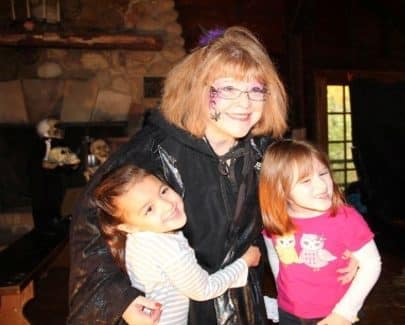 Girls hug a Spookamaga volunteer witch